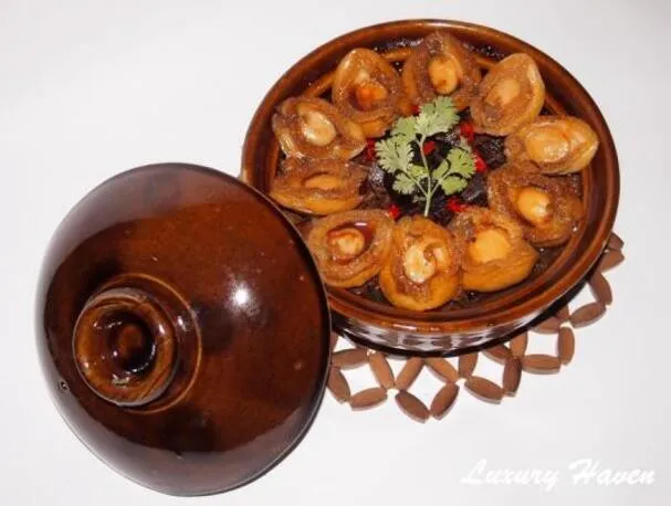 Gestoofde varkensbuiken met abalone in een aardewerken pot